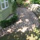 Pflasterweg rund um ein Gartenhäuschen